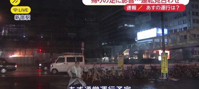 放送事故！？新宿駅からの台風中継に、カッパを着てギターを熱唱する男が映り込む