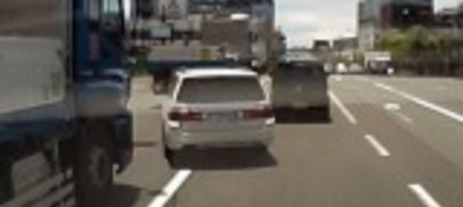 大型トラックの間に無理に割り込もうとする車